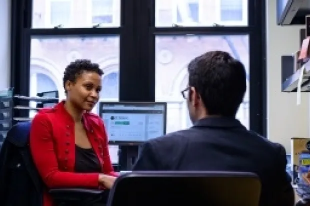 Woman and man wearing business casual clothes talking in office 