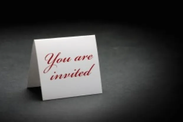 folded white paper that stands up and says "you are invited" in red letters