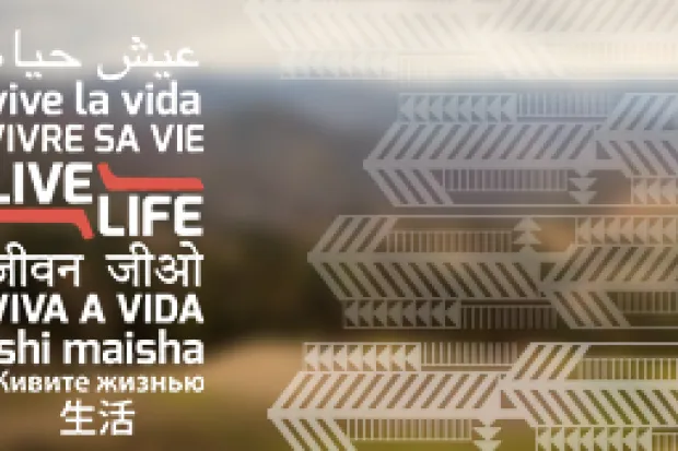 Live Life written in different languages on blurred landscape background