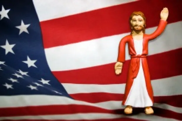 Jesus action figure standing in front of American flag backdrop