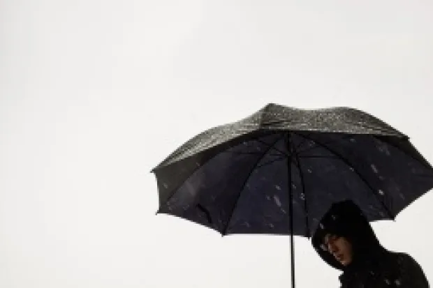 a person standing under an umbrella on a cloudy day