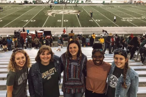 Kerrington standing with group of friends at football game