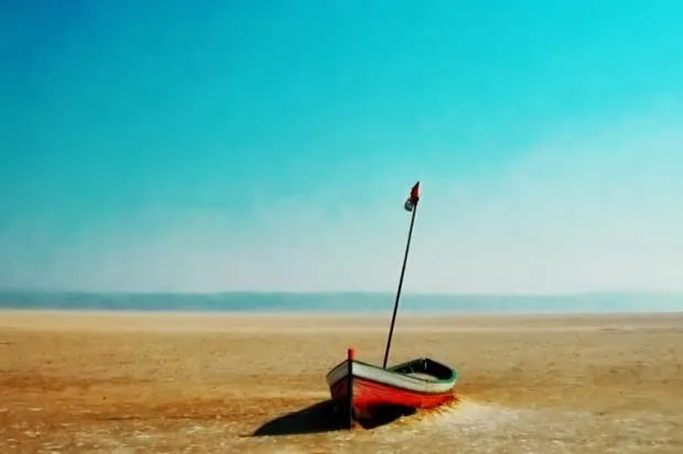 Red sailboat beached in dessert