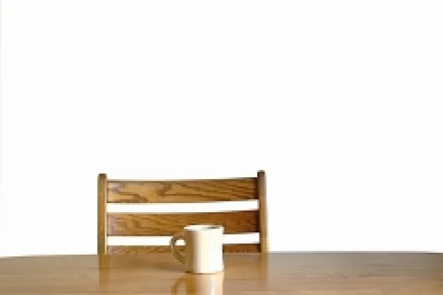 a chair and table with one coffee mug resting on  it