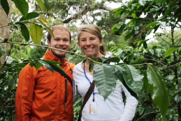 a couple smiling together in a wooded area