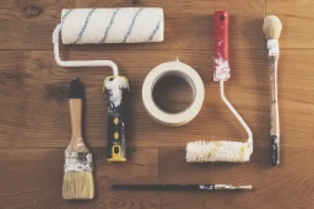 Set of tools on table including paint rollers and brushes