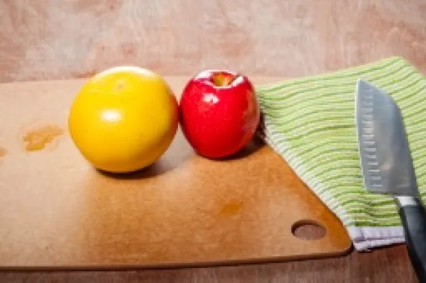 a wooden table with fruits, vegetables, and knife