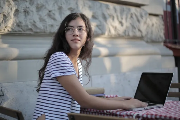 Young woman sitting outside working on computer