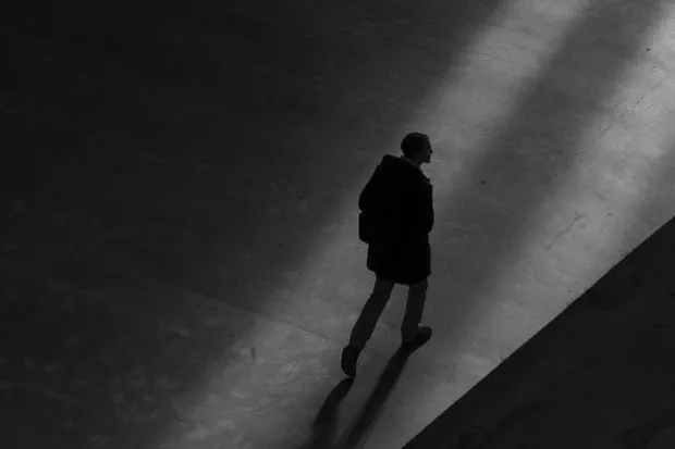 Black and white image of man walking alone