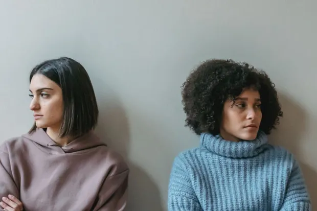 Two women next to each looking frustrated, refusing to make eye contact