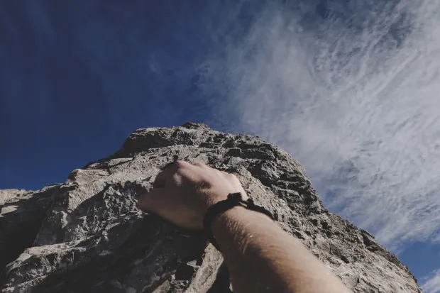 Closeup of a person's hand as she climbs mountain