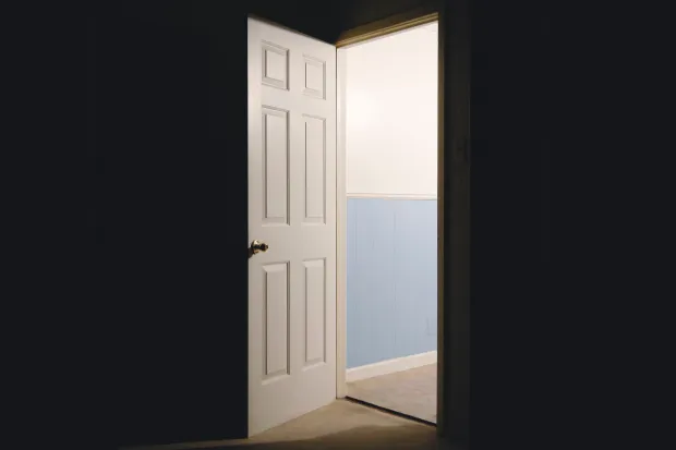 a well-lit open door surrounded by darkness