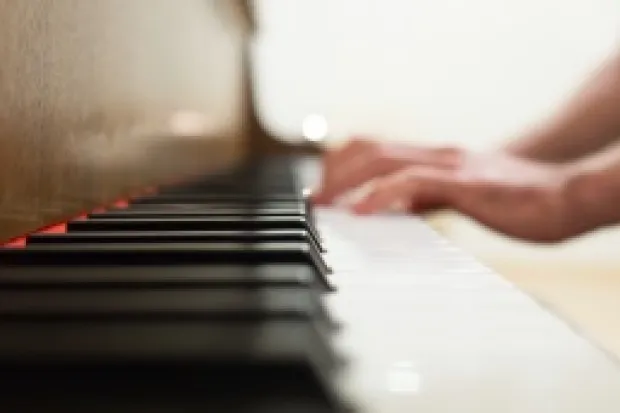 Closeup of person's hands on piano keys