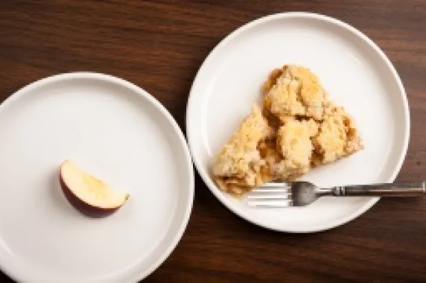 Plate with appetizing piece of pie next to another plate with a single apple slice