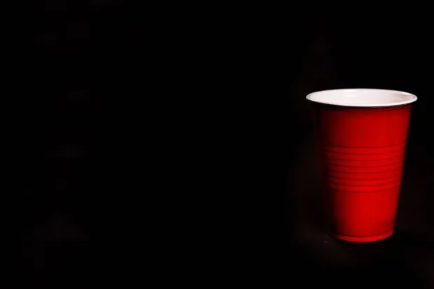 a red plastic up against a black background.