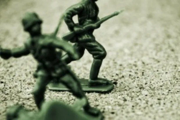 An image of toy soldiers in sand