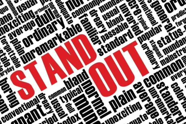 the words "STAND OUT" in red with other smaller words in black surrounding it