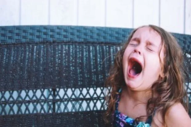 Young girl closing eyes, crying and yelling