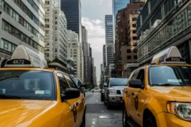 Yellow taxis on a crowded city street surrounded by skyscrapers