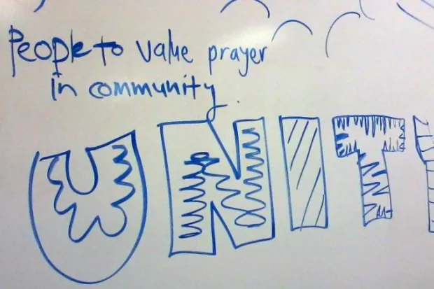 Whiteboard with "People to value prayer in community. Unity" written in large blue letters