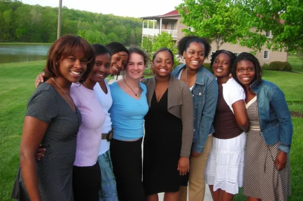 Group photo of Black and White female students in front of woods and pond