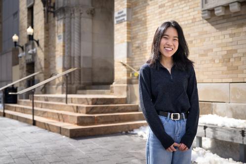 Hannah posing and smiling for a photo on campus