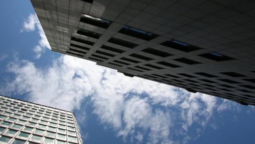 a blue sky with white clouds above two skyscrapers