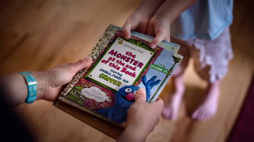 The hands of two children fighting over picture book