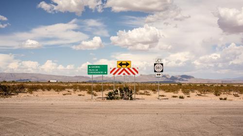 Dusty road dead end with several street signs