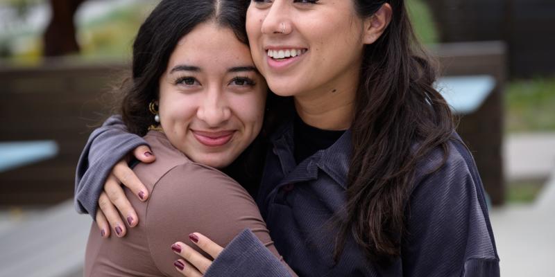 two women hugging on campus