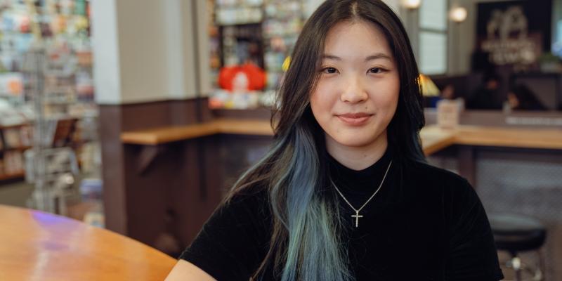 woman sitting at coffee shop and smiling at camera