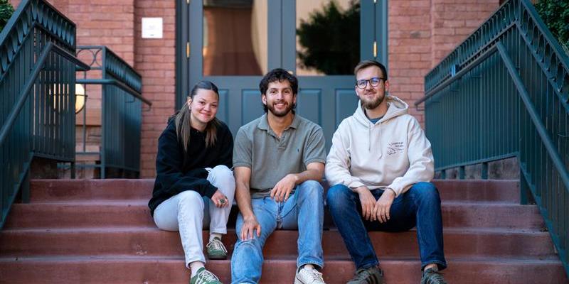 Elijah sitting on steps with two friends