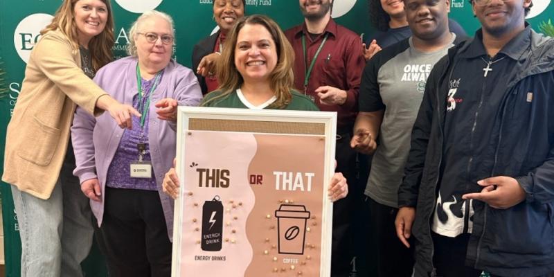 Group of students on campus with poster