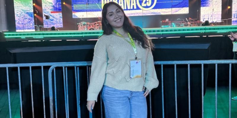 Angelica smiling in front of stage at Urbana 25