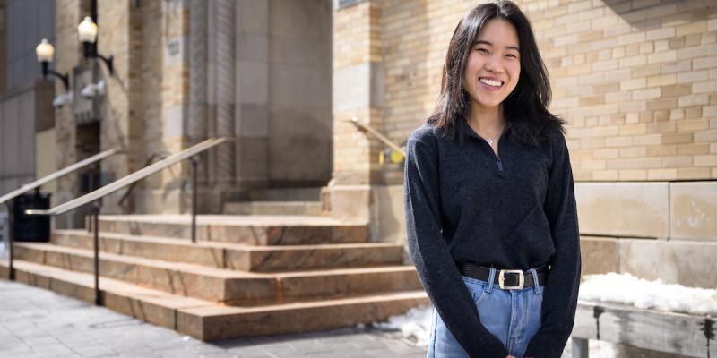 Hannah posing and smiling for a photo on campus