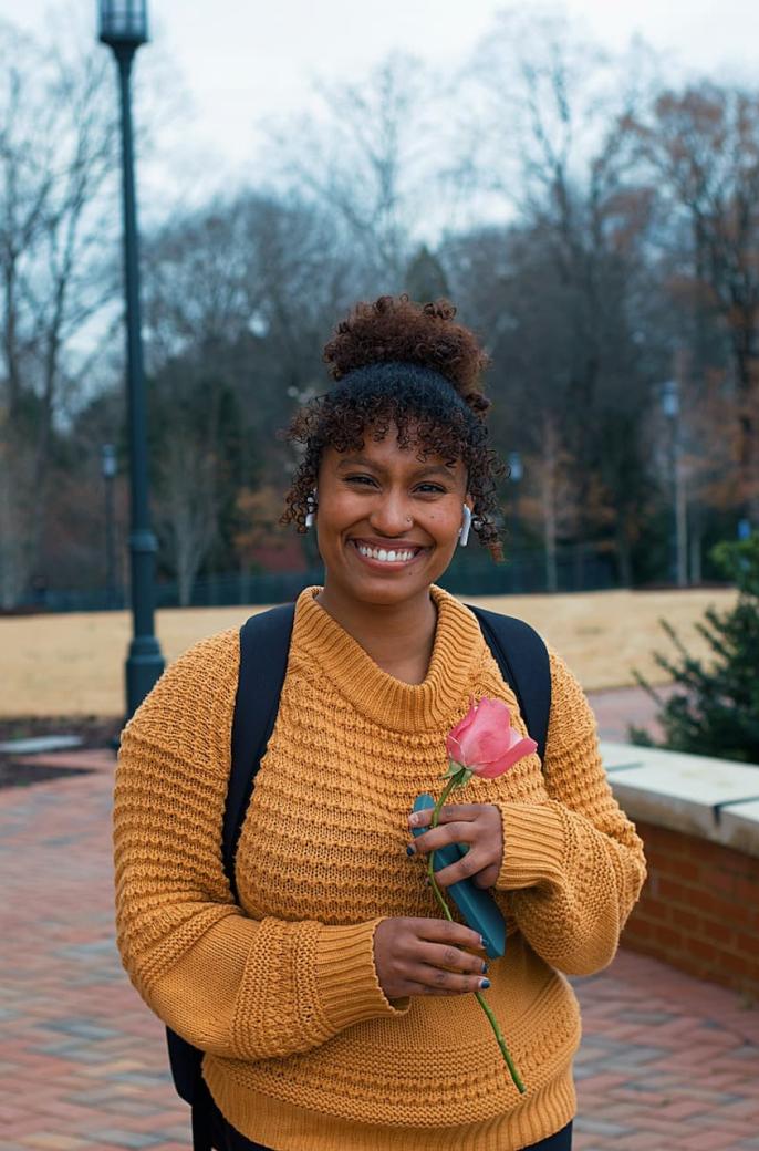 black student holding a flower