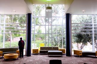 man standing left of center in empty student union