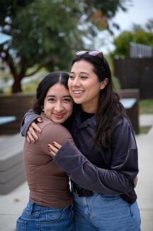 two women hugging on campus