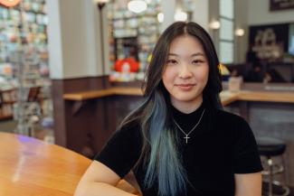 woman sitting at coffee shop and smiling at camera