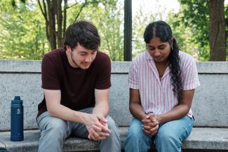 two staff praying outside