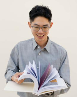 man smiling reading a book