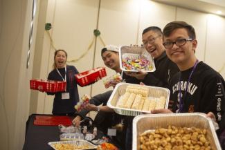 Students at Native IV conference smiling and holding food 