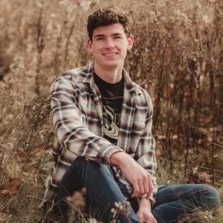 portrait of Austin sitting outside 