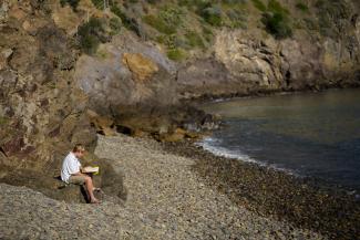 student reading and praying by water