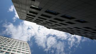 a blue sky with white clouds above two skyscrapers