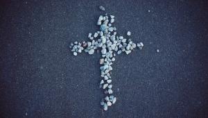 A white and gray cross formed out of small pebbles