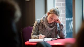 a woman seated at a round table and journaling