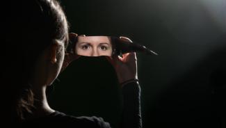 a woman's eyes reflected in a shard of glass