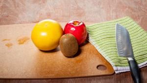 a wooden table with fruits, vegetables, and knife