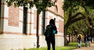 Several students walking down sidewalk on campus